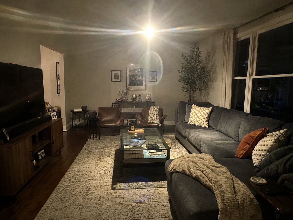 An unshielded downlight causing harsh glare and lens flare in a living room