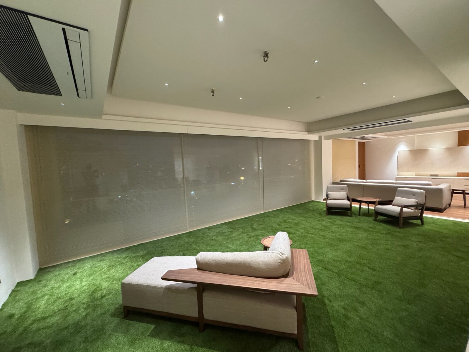 J. Bhalodia Residence lounge with artificial turf flooring and automated blinds