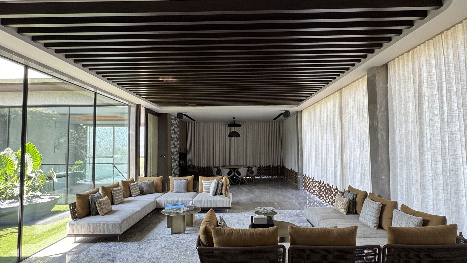 Open-plan living room with automated drapery and architectural lighting at the Rohan Kataria residence
