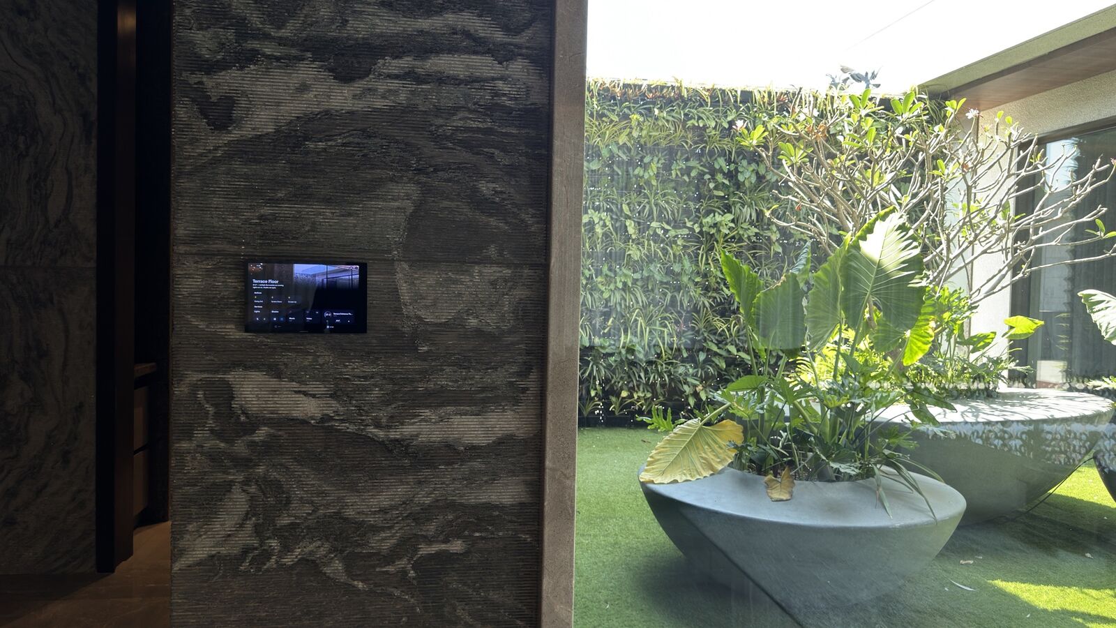 Wall-mounted control touchpanel in the courtyard at the Rohan Kataria residence